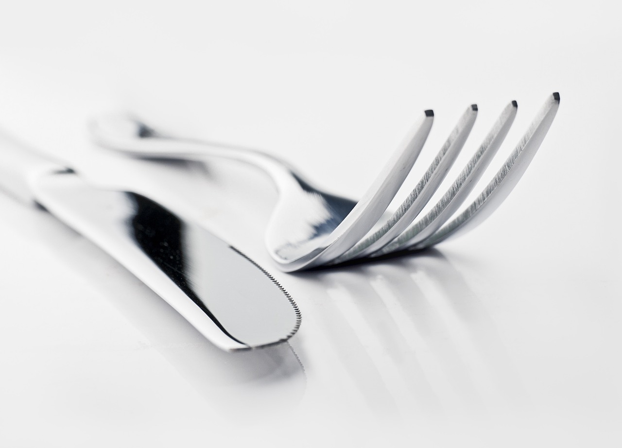 a close up of a fork and a knife on a table, by Matija Jama, high key detailed, smooth shiny metal, waist - up, set against a white background