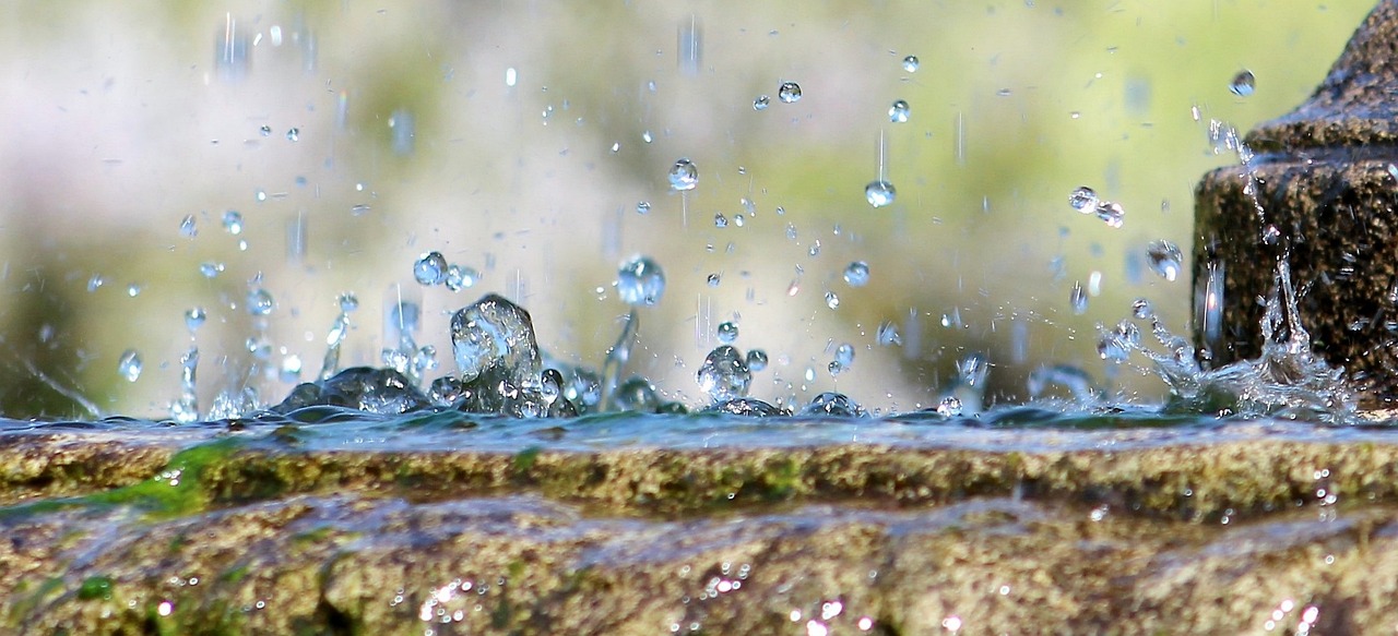 a close up of a fountain with water coming out of it, a picture, by Mirko Rački, pixabay, raindrops, seen from below, water flows inside the terrarium, water particle in front