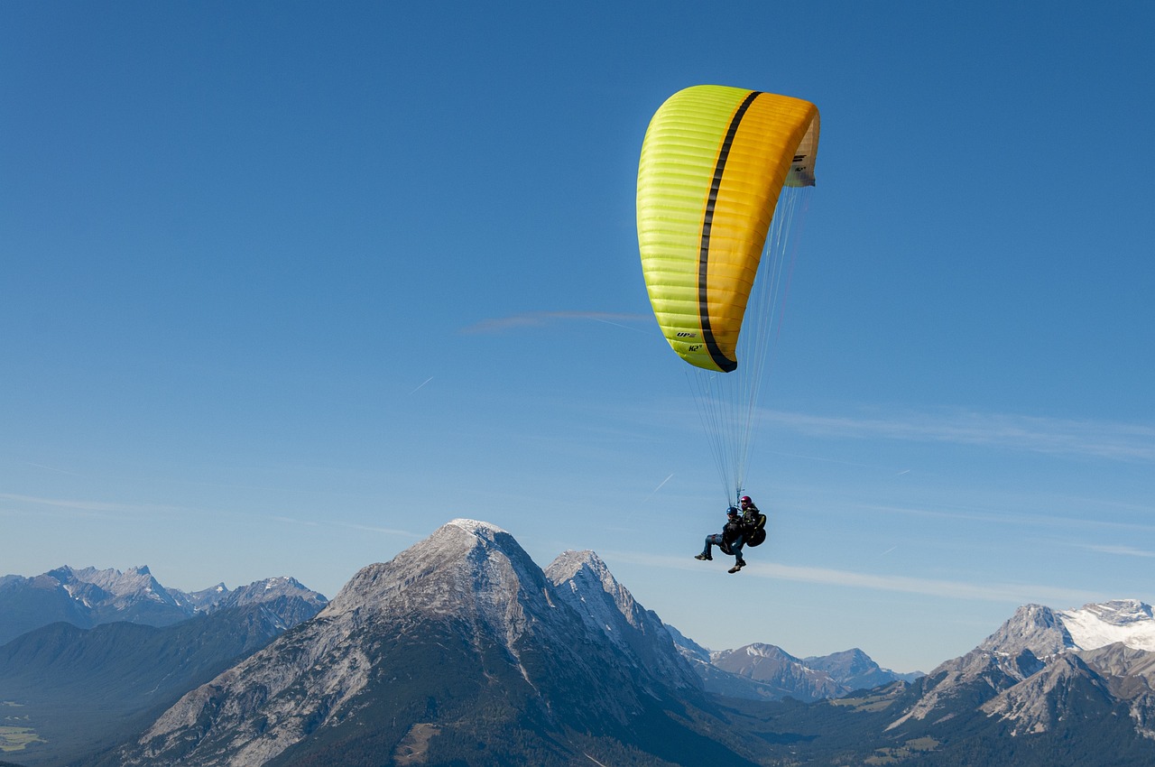 a person that is in the air with a parachute, by Jan Rustem, shutterstock, epic mountains in the background, chartreuse and orange and cyan, ergonomic, chris moore”