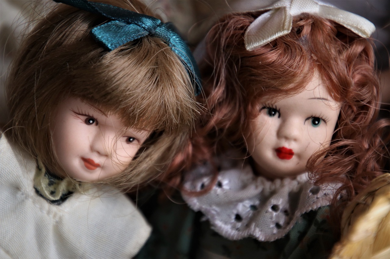 a couple of dolls sitting next to each other, a portrait, by Linda Sutton, trending on pixabay, kitsch movement, china doll face, high angle close up shot, 1992, belgium