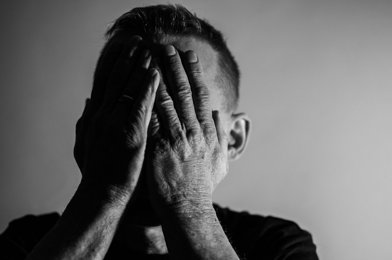 a man covering his face with his hands, a black and white photo, pexels, fine art, ptsd, silhouette of a man, he has a devastated expression, man in his 40s