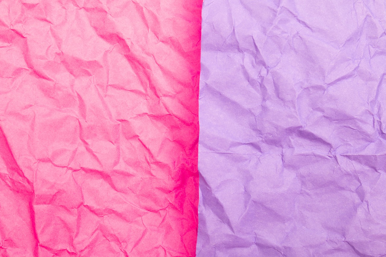 a couple of pieces of paper sitting next to each other, color field, paper crumpled texture, pink and purple, holiday season, close up half body shot