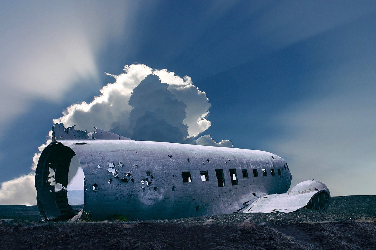 a large airplane sitting on top of a grass covered field, surrealism, salt flats with scattered ruins, vacation photo, the sky falls to the ground, defunct technology
