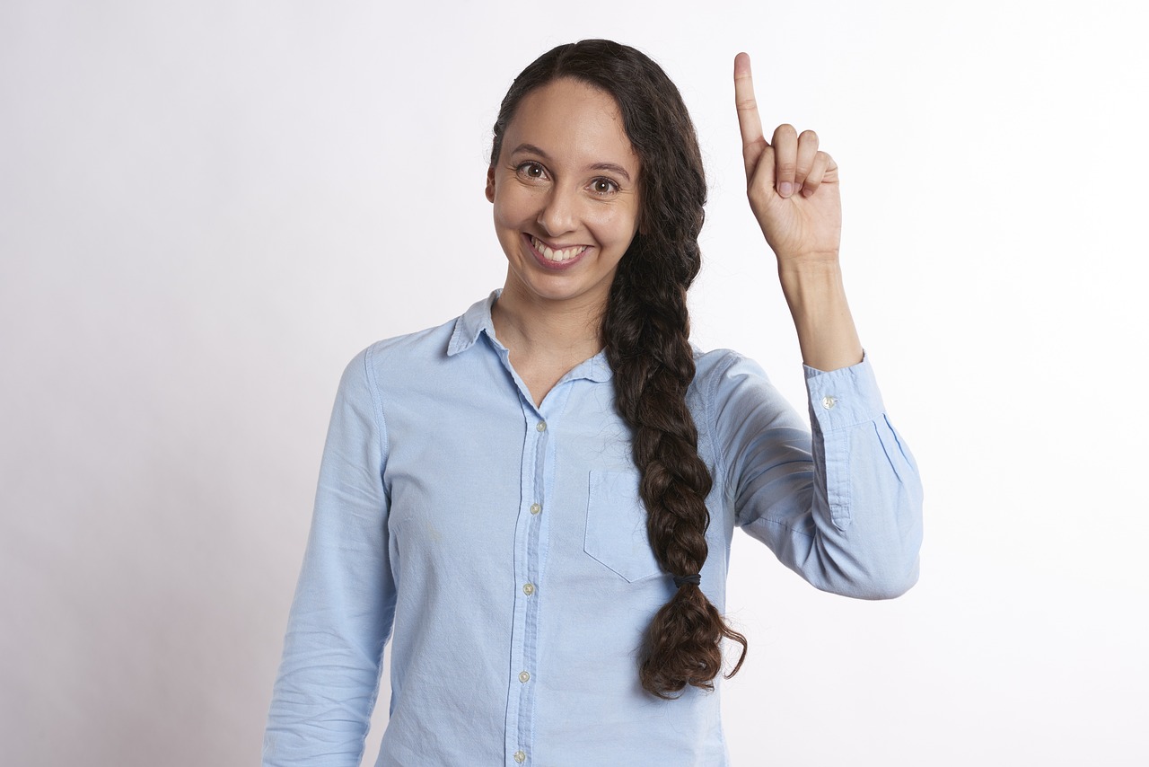 a woman making a peace sign with her hand, a stock photo, woman with braided brown hair, winning award photo, upward shot, latina