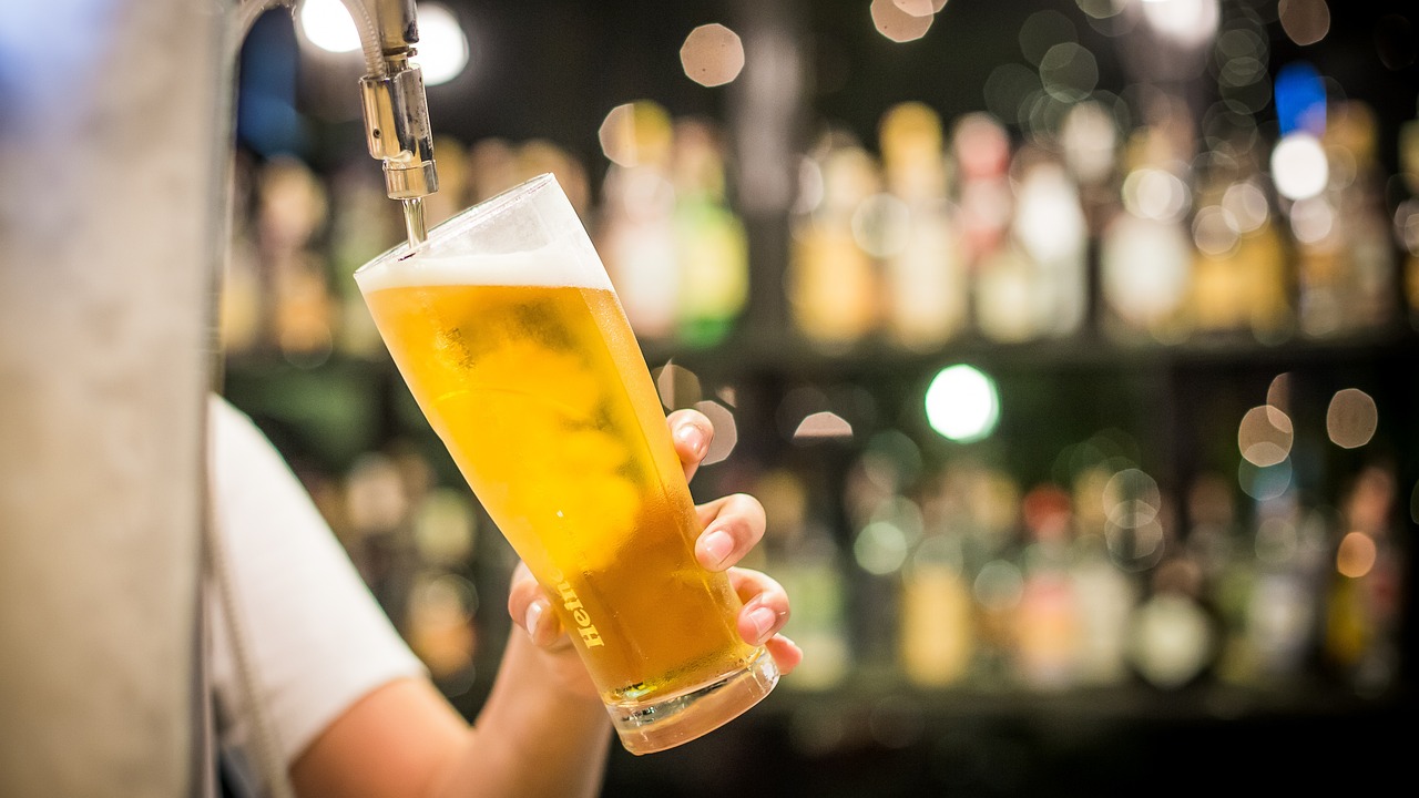 a close up of a person holding a glass of beer, a stock photo, by Adam Marczyński, shutterstock, bartending, instagram post, 555400831, istockphoto