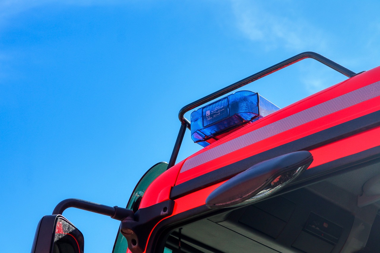 a red fire truck with a blue light on top, shutterstock, low - angle shot from behind, policeman closeup, closeup photo, transparent black windshield