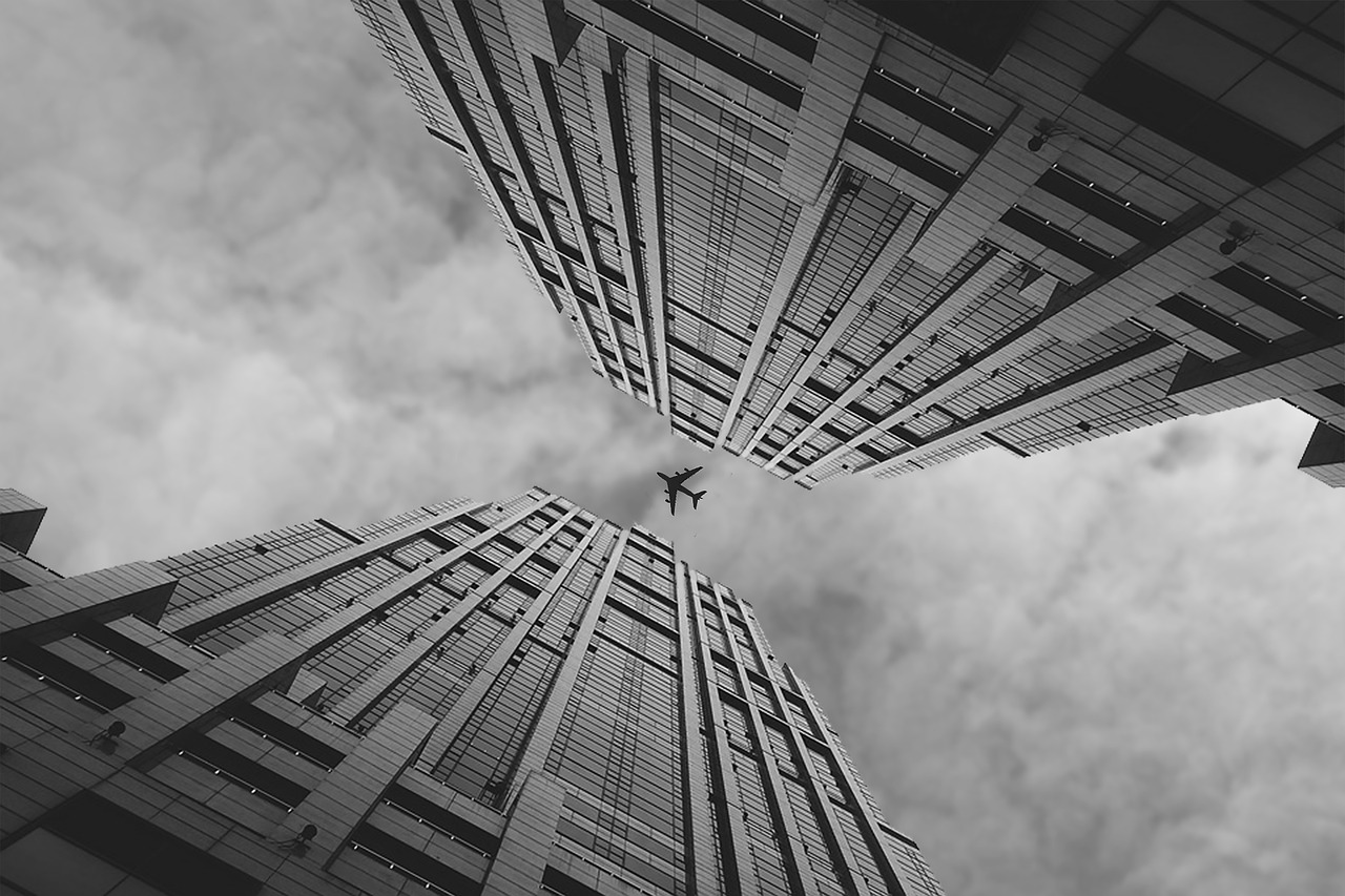 a black and white photo of a tall building, pexels contest winner, surrealism, airplane in the sky, andrei riabovitchev symmetrical, in hong kong, bottom - view