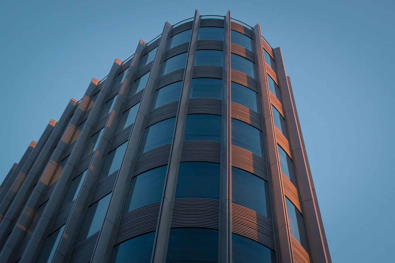 a tall building with a clock on top of it, inspired by Zaha Hadid, flickr, taken at golden hour, circular windows, 8k 50mm iso 10, corona renderer