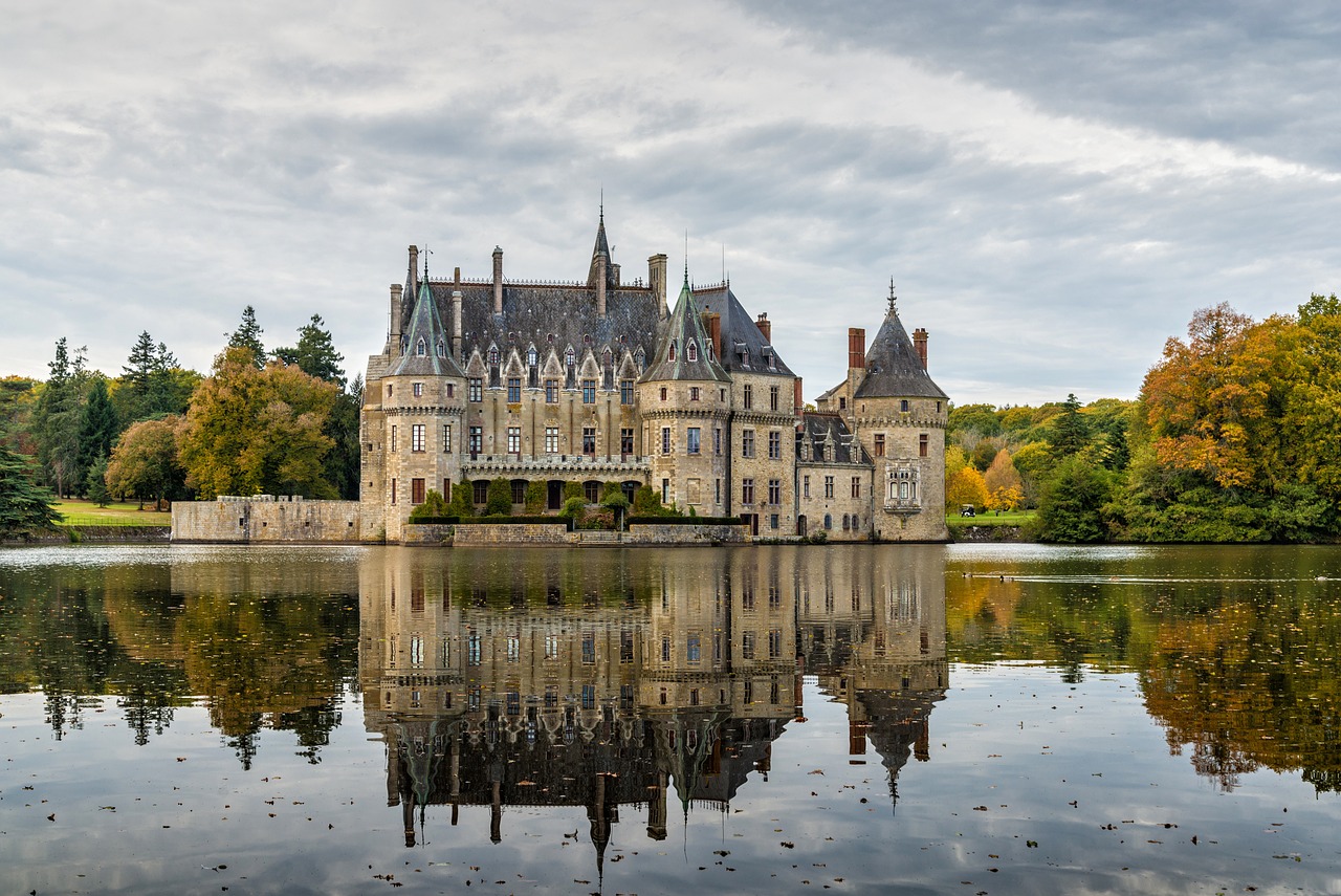 a castle sitting on top of a lake surrounded by trees, a photo, by Etienne Delessert, shutterstock, ornate french architecture, november, gothic mansion, stock photo