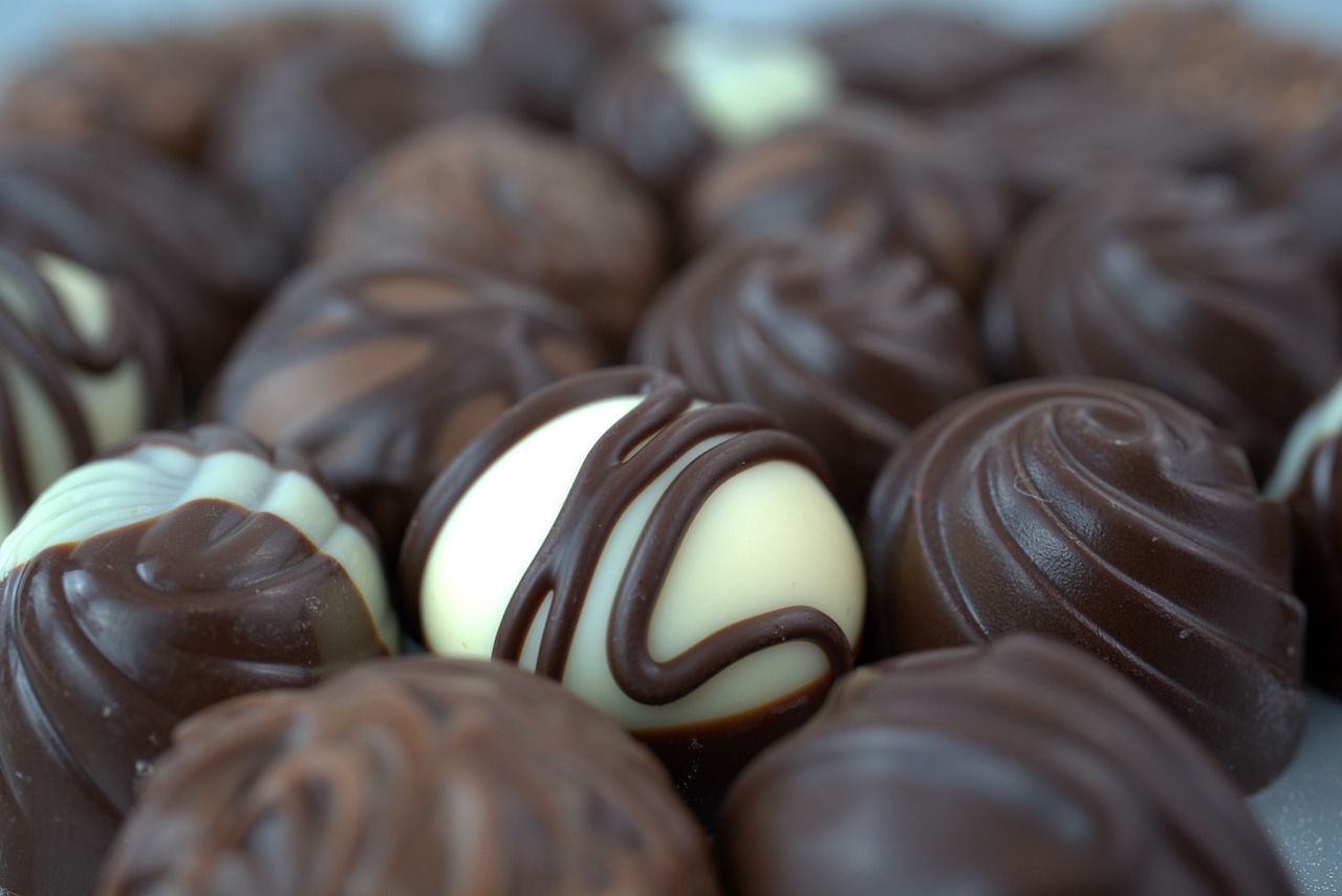 a pile of chocolates sitting on top of a table, pexels, bauhaus, photo realistic”, some spherical, high quality ”, dark sienna and white