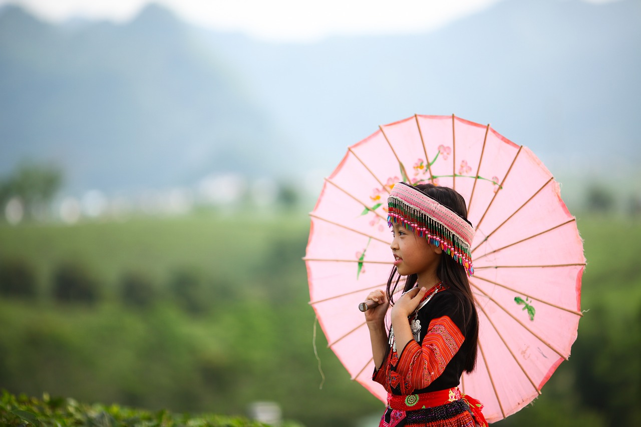 a woman in a red dress holding a pink umbrella, inspired by Miao Fu, shutterstock, sumatraism, beautiful little girl, mountain, wearing an elegant tribal outfit, stock photo