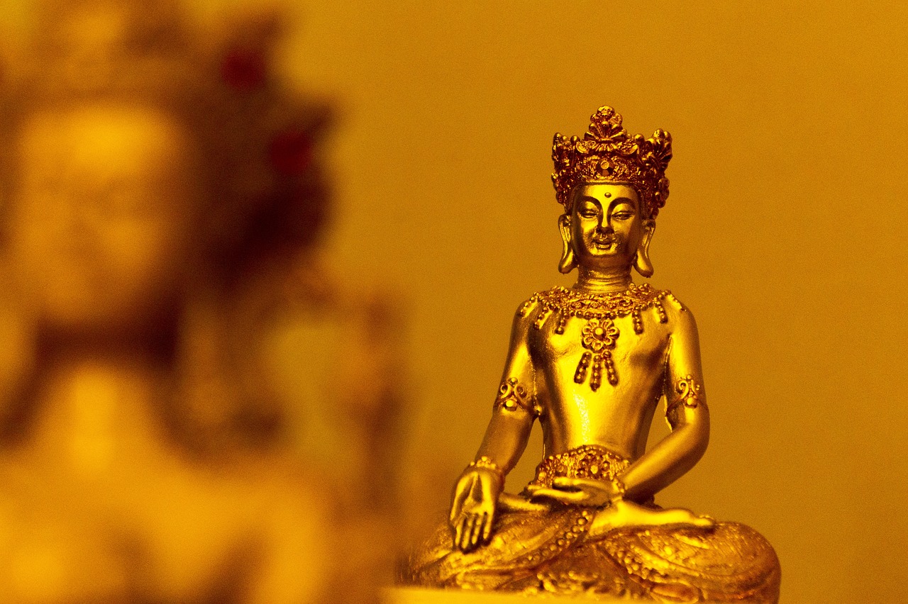 a golden buddha statue sitting on top of a table, a statue, by Joseph Werner, close up shot of an amulet, wallpaper - 1 0 2 4, golden crown, yoga meditation pose