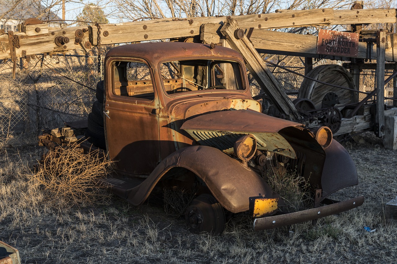 an old rusted truck sitting in a field, a portrait, by Arnie Swekel, shutterstock, taken at golden hour, new mexico, with a roof rack, burned cars