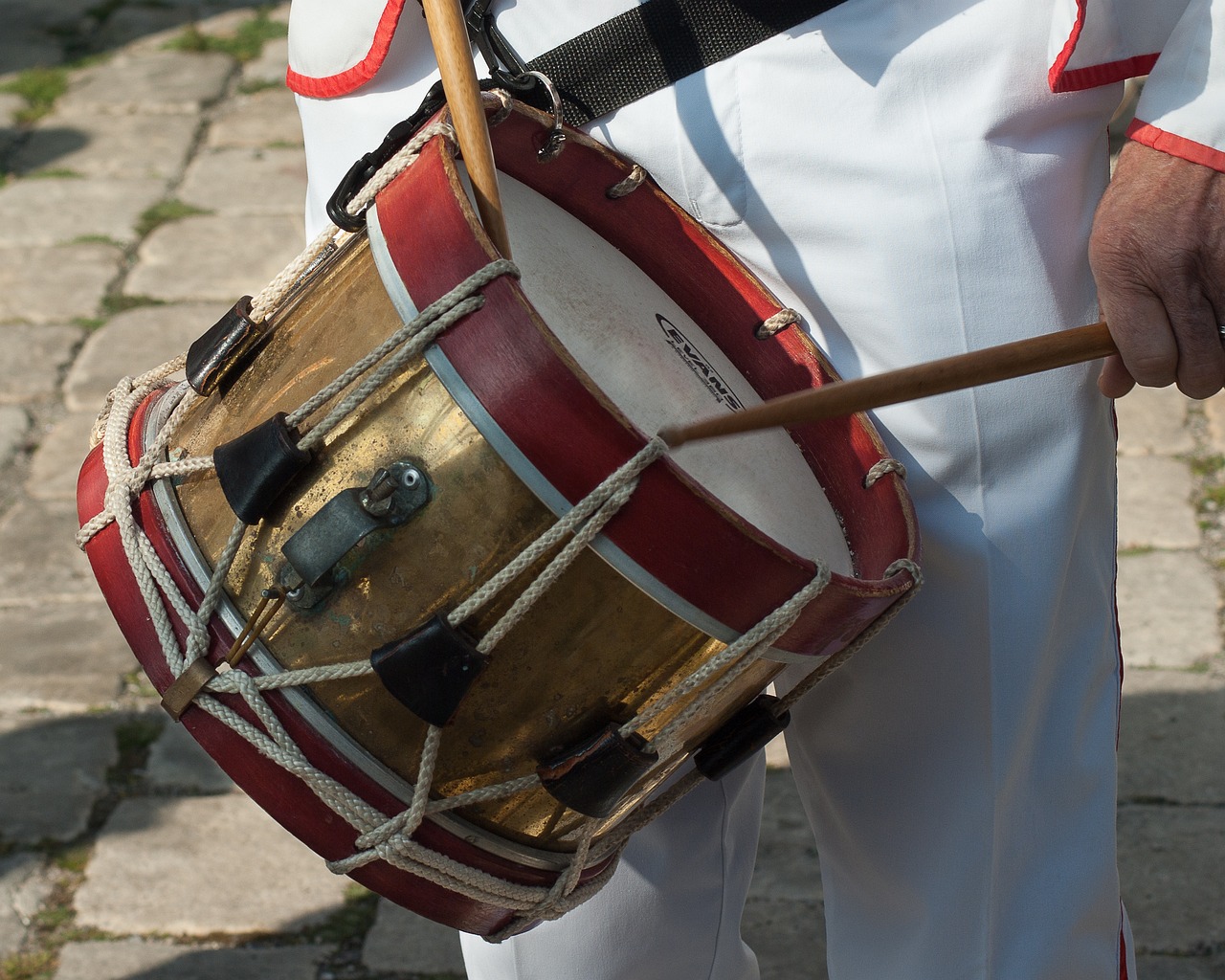 a close up of a person holding a drum, by Robert Brackman, shutterstock, xix century military outfit, white red, italian, high details photo