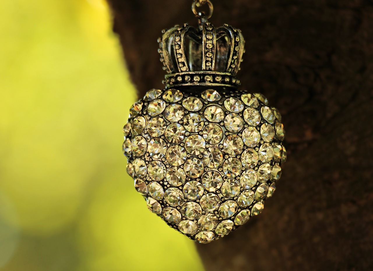 a heart shaped ornament hanging from a tree, by Maksimilijan Vanka, pixabay, romanticism, ornate crystal crown hood, golden dapple lighting, wearing a diamond crown, high angle close up shot