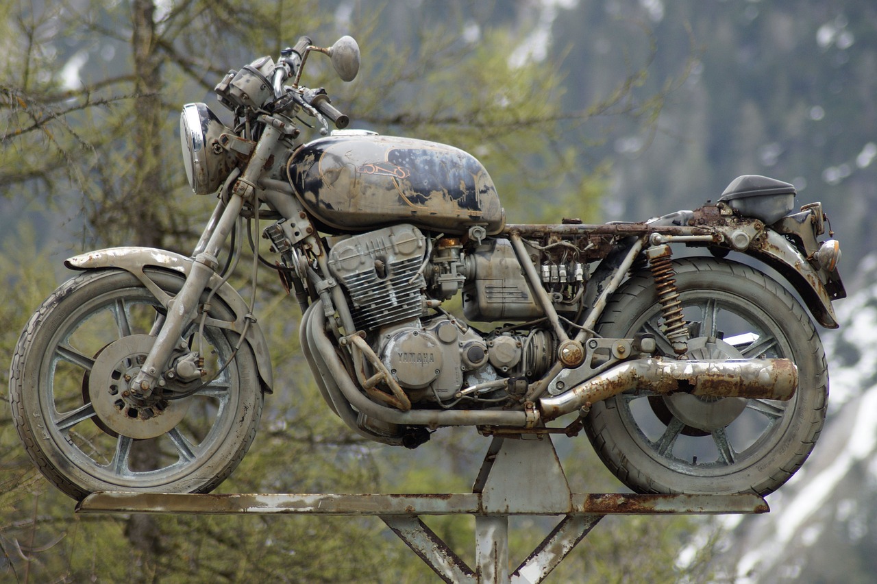 an old motorcycle sitting on top of a metal pole, by Richard Carline, trending on pixabay, photorealism, chemically damaged, akira motorcycle, photorealistic - h 6 4 0, covered in mud