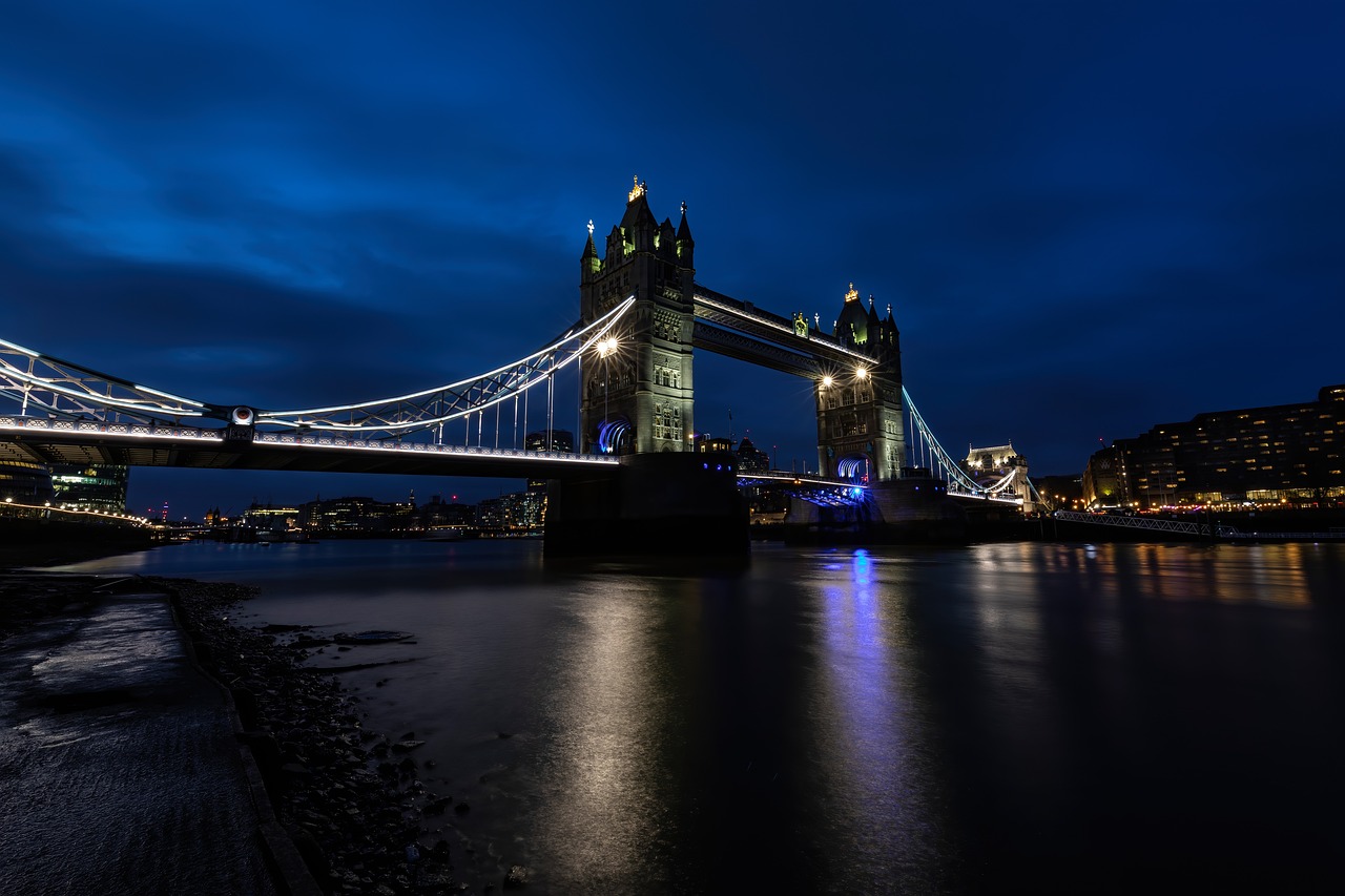 a bridge over a body of water at night, a photo, by Richard Carline, shutterstock, tower bridge, low key light, blue hour photography, stock photo