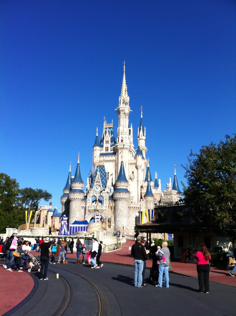 a group of people standing in front of a castle, by Walt Disney, flickr, blue clear skies, majestic!!! beautiful!!!, spire, sunday