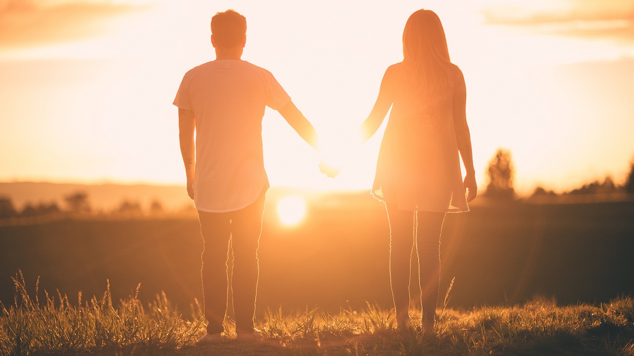 a man and a woman holding hands as the sun sets, sunny lighting, however, shaded, head-to-shoulder