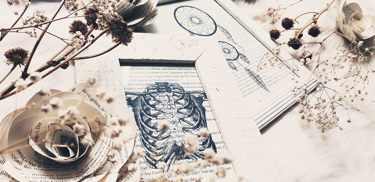 a book sitting on top of a table next to a cup of coffee, an etching, inspired by Joseph Cornell, featured on behance, vanitas, rib cage, pressed flowers, 🪔 🎨;🌞🌄, flatlay