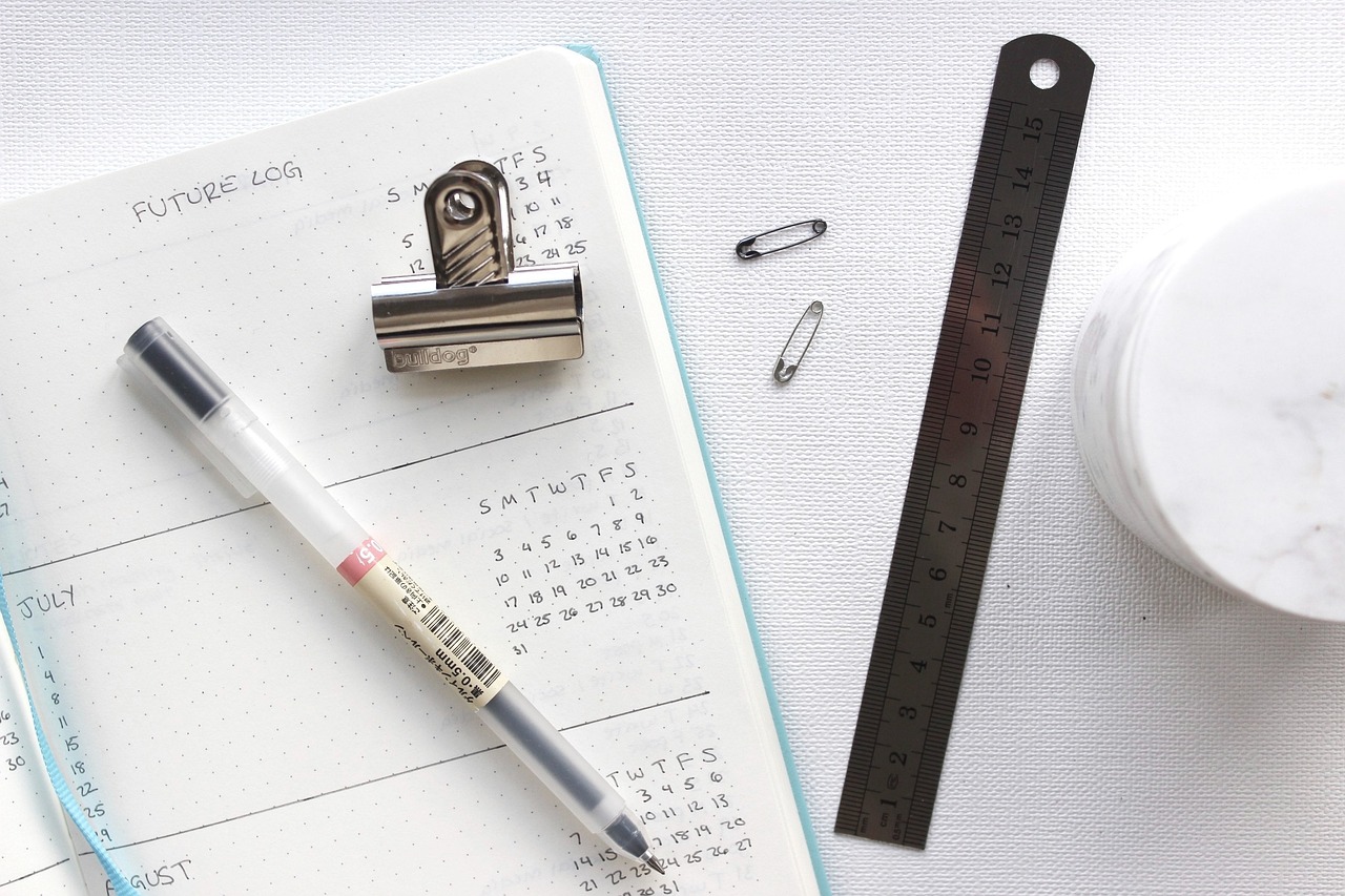 a pen sitting on top of a notebook next to a ruler, a picture, flatlay, well list, 35 mm product photo”