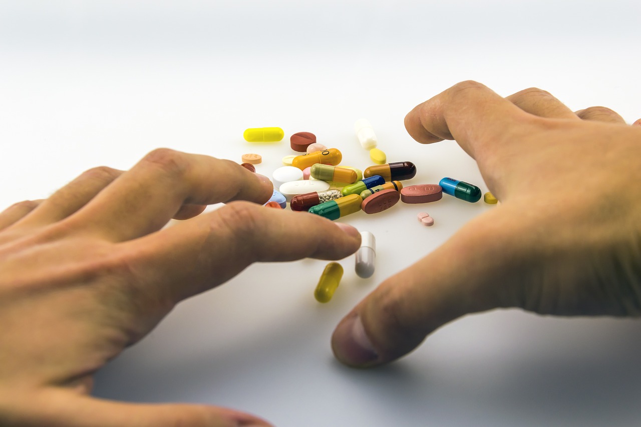 a close up of a person holding a bunch of pills, a picture, antipodeans, human hands, product introduction photo, wide range of colors, wide shot photo