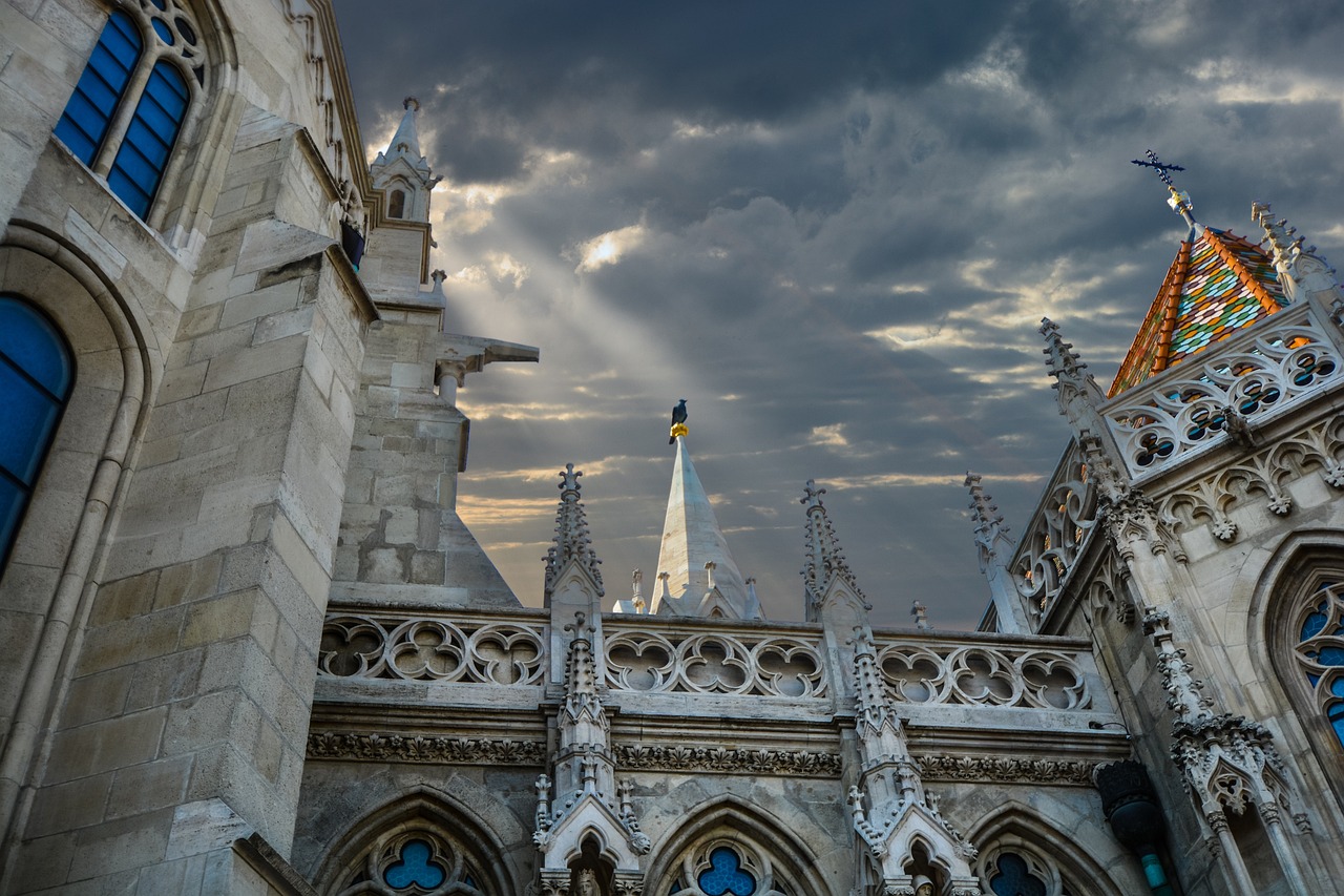 a very tall building with a clock on it's side, by Ludovit Fulla, shutterstock, baroque, alabaster gothic cathedral, with dramatic sky, gods eye view, budapest