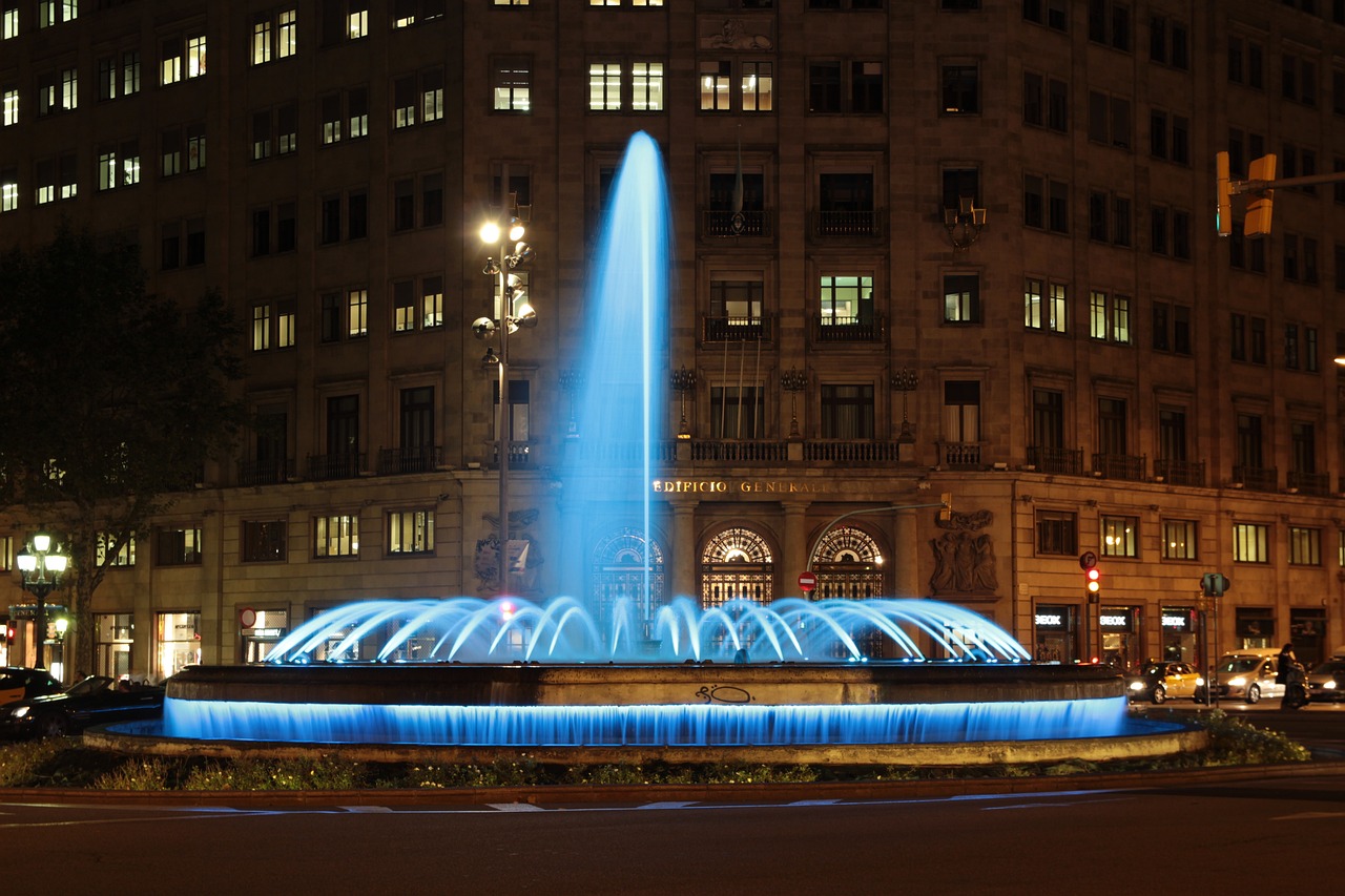 a blue fountain in the middle of a city at night, by Cherryl Fountain, shutterstock, victor horta, avenida paulista, subsurface light transmission, high res photo