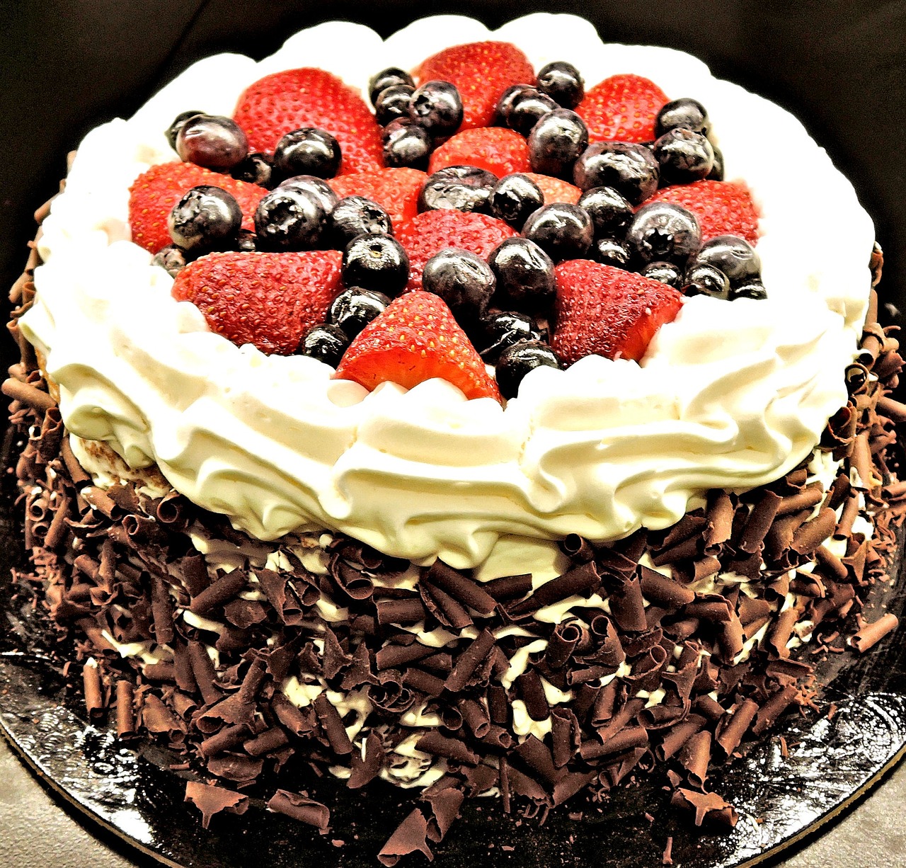 a chocolate cake with strawberries and blueberries on top, renaissance, very high contrast, happy birthday, black forest, whipped cream on top