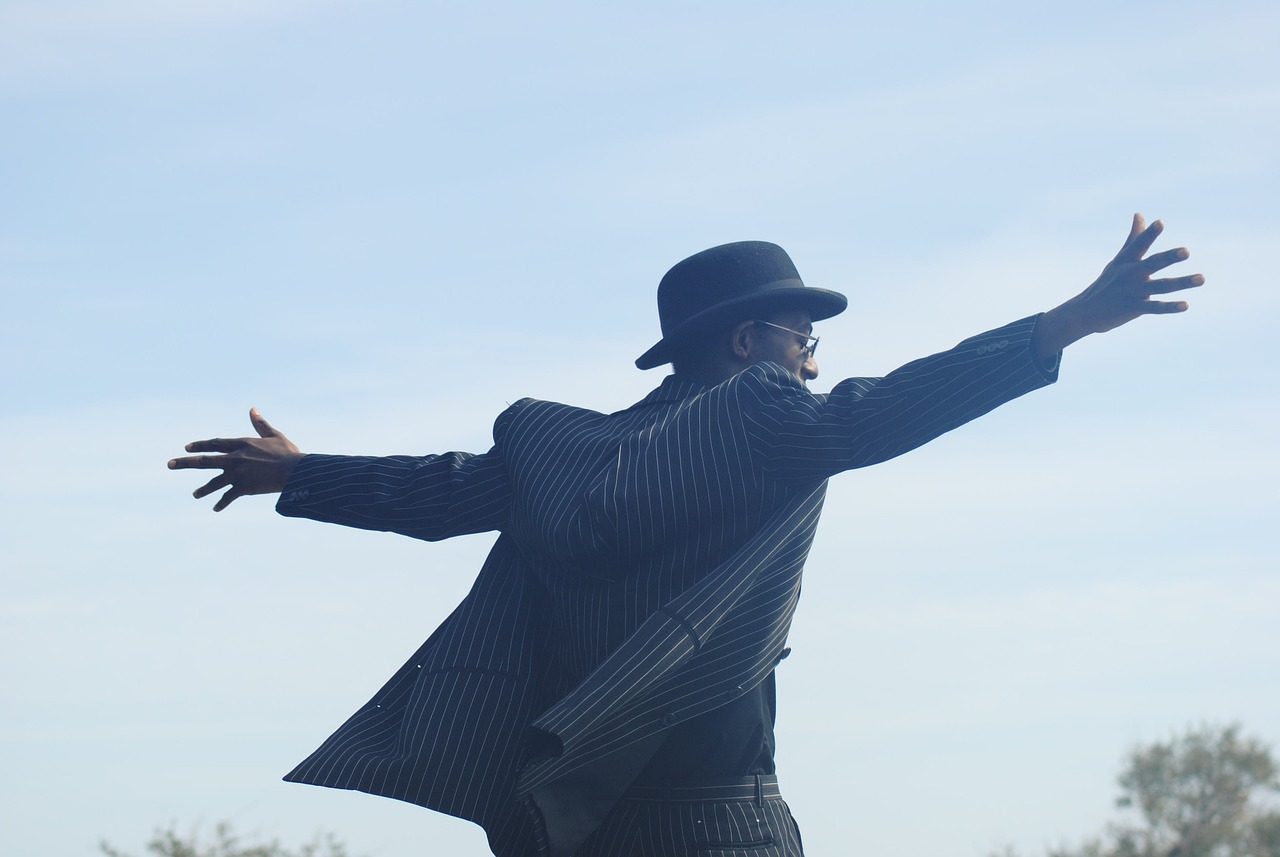 a man in a suit and hat throwing a frisbee, a photo, figuration libre, pointing to heaven, black man, wearing a pinstripe suit, dancing character