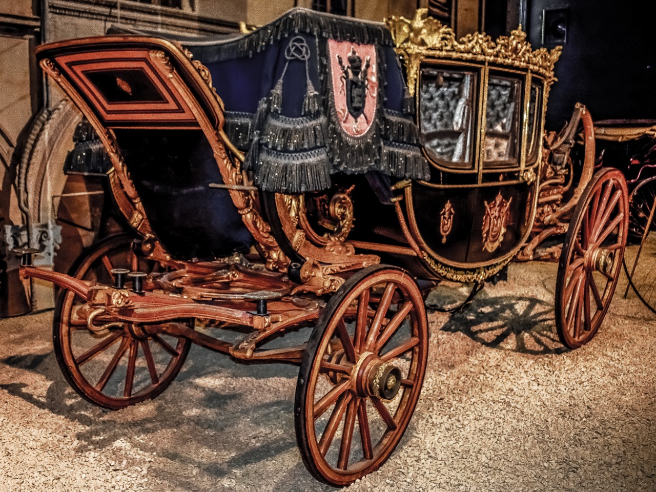a horse drawn carriage sitting in front of a building, a colorized photo, by Mirabello Cavalori, shutterstock, baroque, dark ornate royal robes, displayed in the exhibition hall, hdr photo, royal crown