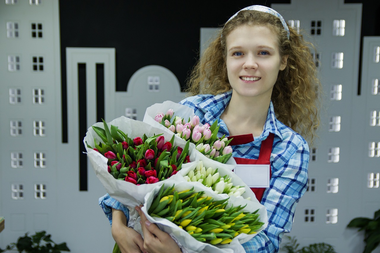 a woman holding a bunch of flowers in her hands, a picture, advertising photo, tulips, wearing an apron, good lighted photo