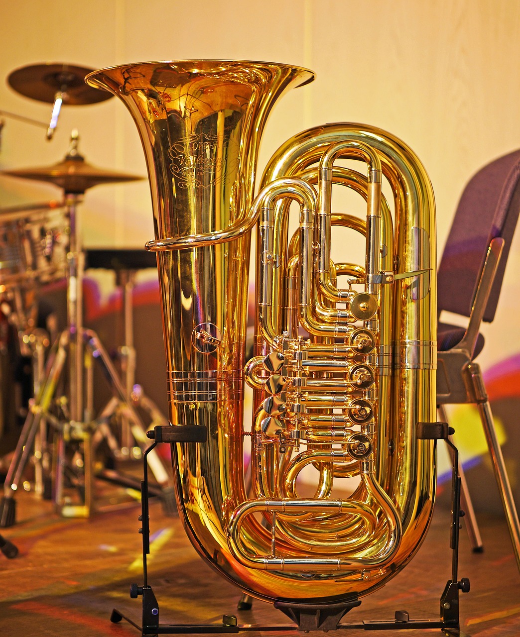 a brass instrument sitting on top of a wooden table, by Linda Sutton, shutterstock, with big chrome tubes, shiny plastic, florida, stock photo