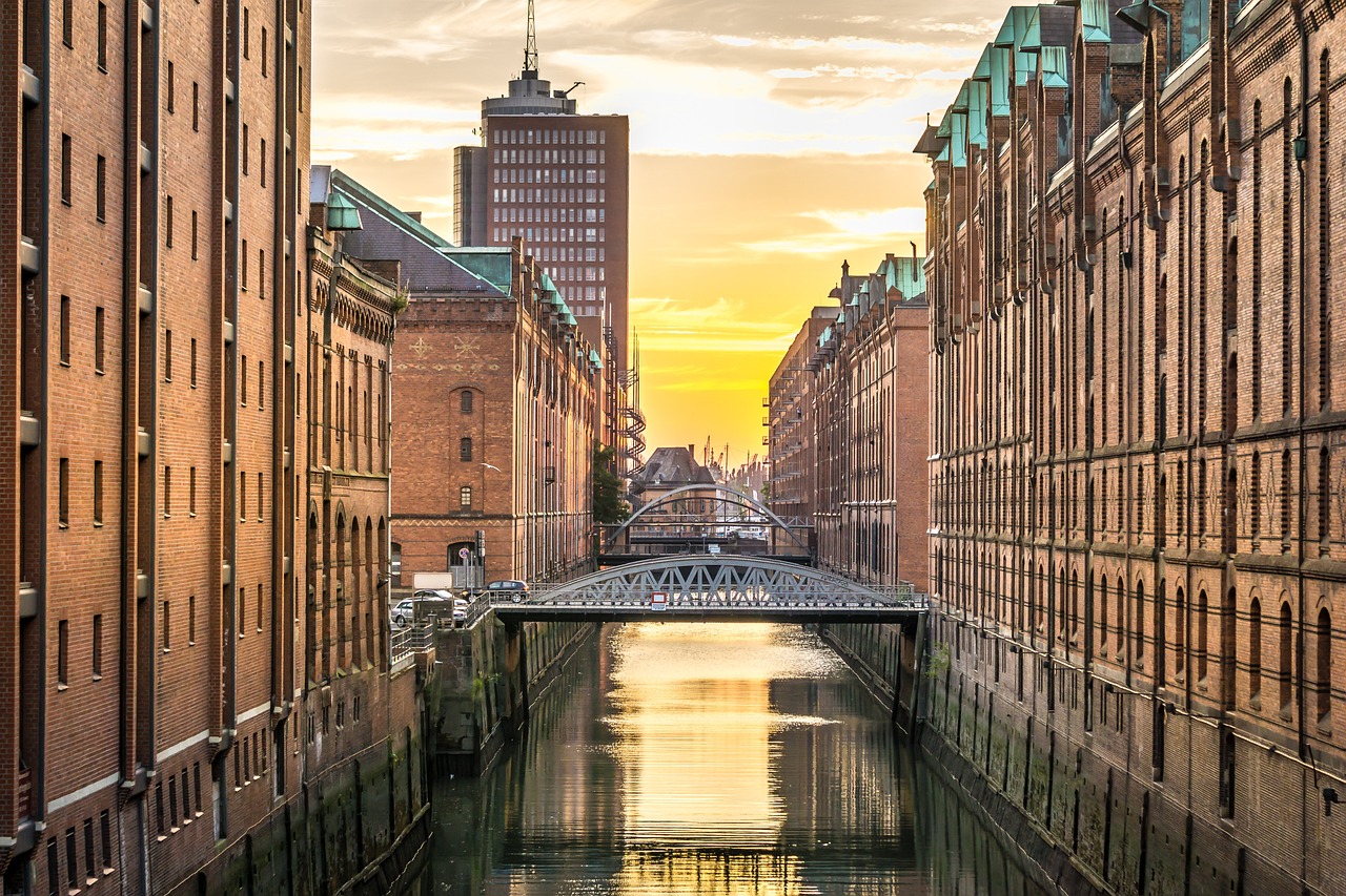 a river running through a city next to tall buildings, a photo, by Jakob Gauermann, shutterstock, golden hour sunlight, hannover, railing along the canal, stock photo