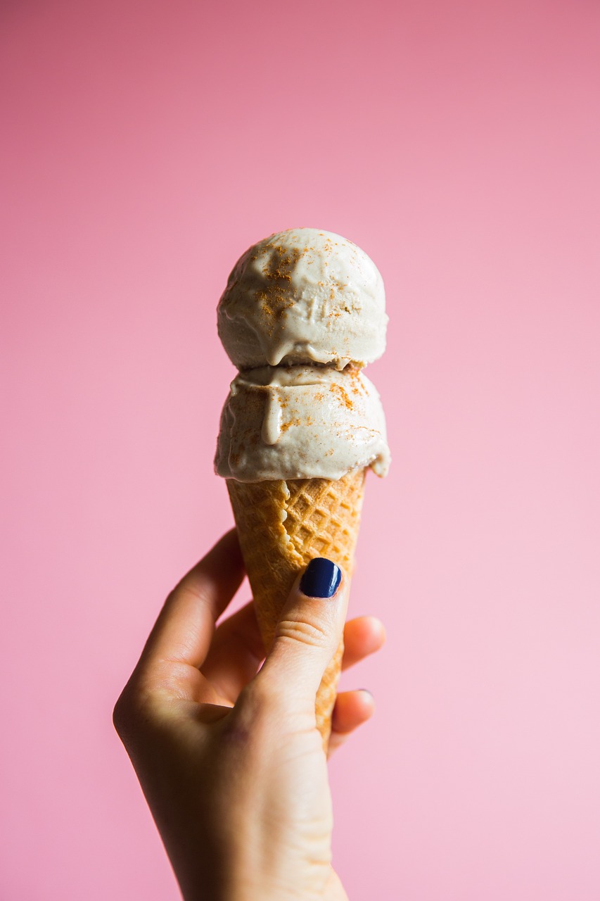 a hand holding an ice cream cone against a pink background, a portrait, by Juliette Wytsman, unsplash, epicurious, recipe, beautiful texture, on grey background