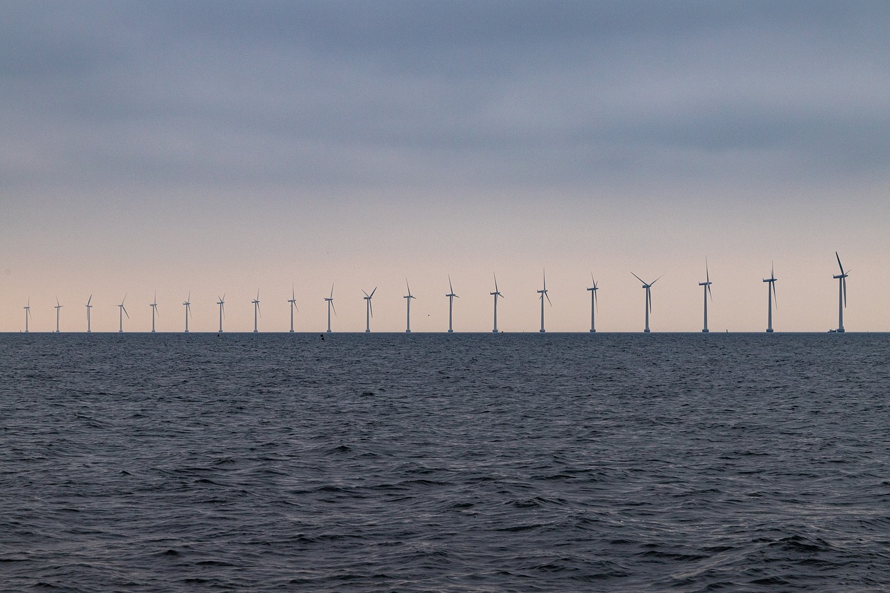 a large body of water with a bunch of windmills in the background, by Jens Søndergaard, pexels, purism, photo of the middle of the ocean, lined up horizontally, trident, seen from the long distance