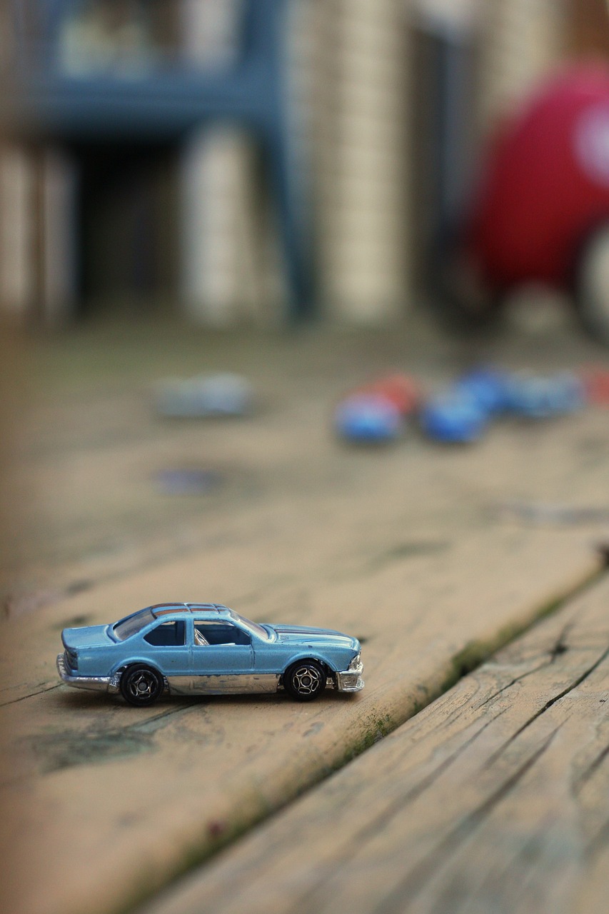 a toy car sitting on top of a wooden floor, a tilt shift photo, some zoomed in shots, found objects, lowrider style, 1 9 8 3