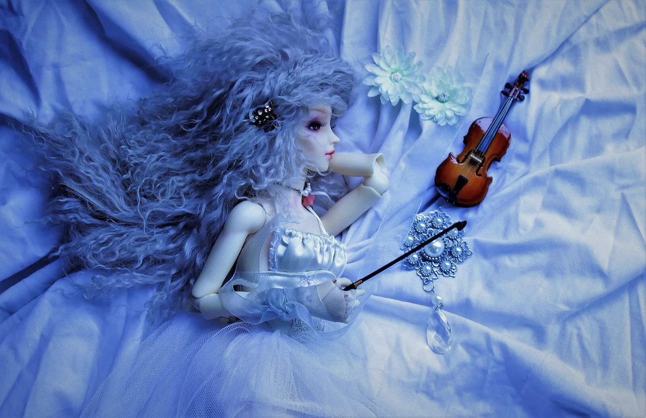 a doll sitting on top of a bed next to a violin, inspired by Louis Grell, cold blue tones, in the astral plane ) ) ), ophelia, graceful beauty