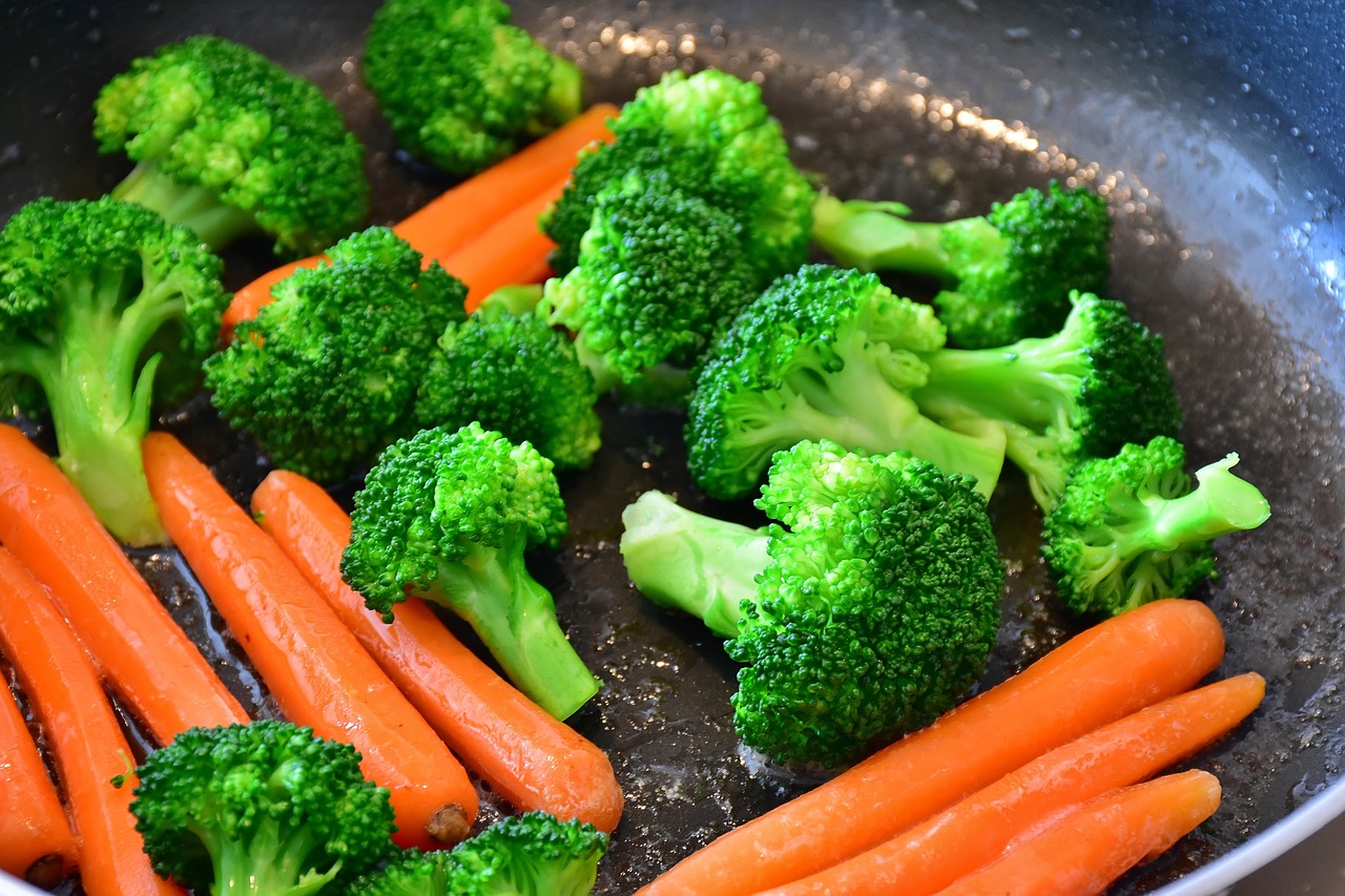 a frying pan filled with carrots and broccoli, by Paul Emmert, pexels, hurufiyya, bottom viev, reflexes, chinese, steel