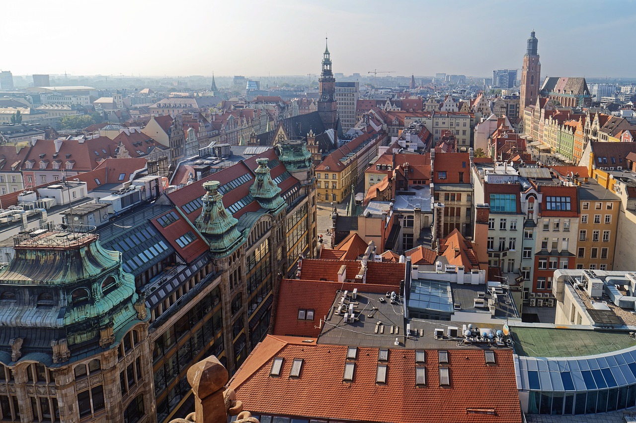 a view of a city from the top of a building, inspired by Jan Konůpek, shutterstock, trip to legnica, wide wide shot, benjamin vnuk, hull