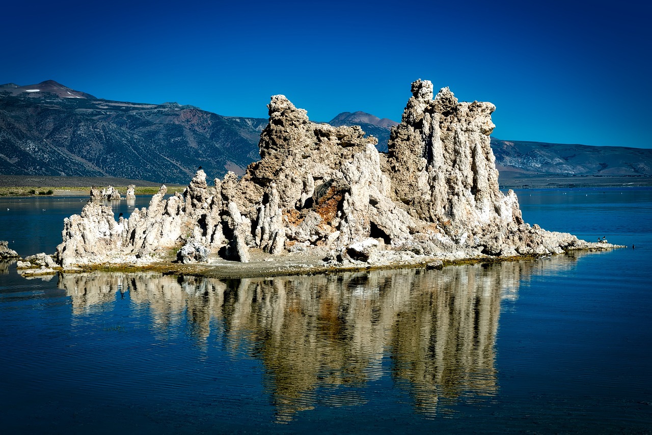 a rock formation in the middle of a body of water, a photo, ivory towers, detailed reflections, polarizer, tourist photo