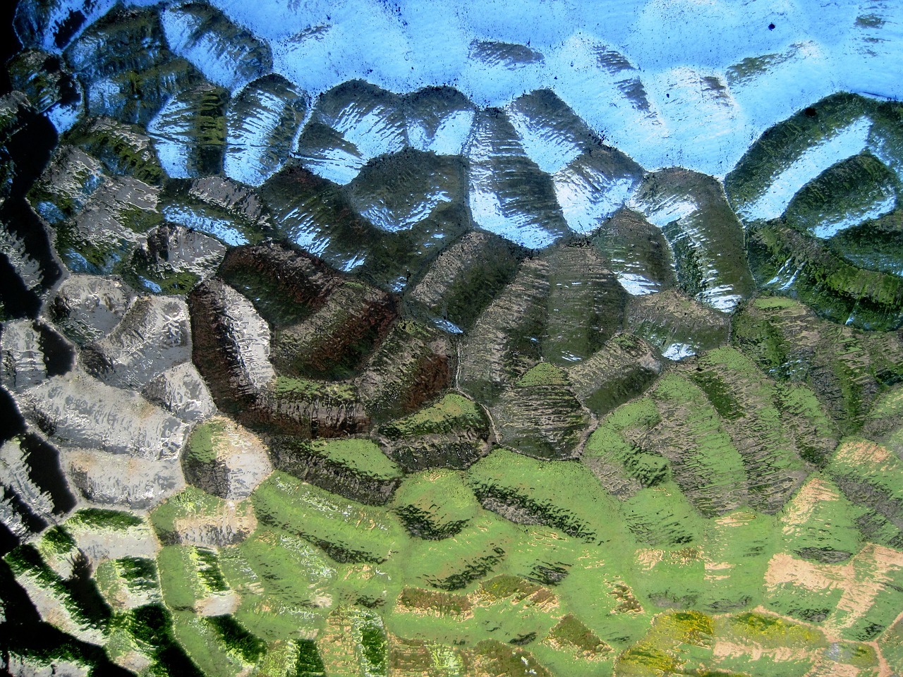 a close up of a painting of a mountain range, a macro photograph, by Jan Rustem, flickr, panfuturism, green stained glass, shed iridescent snakeskin, transparent corrugated glass, dappled afternoon sunlight