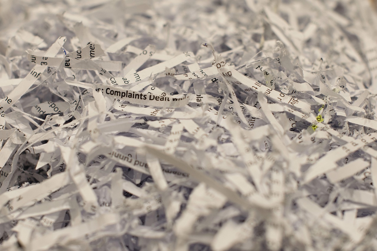 a pile of shredded paper sitting on top of a table, plasticien, complaints, word, white ribbon, close - up on detailed