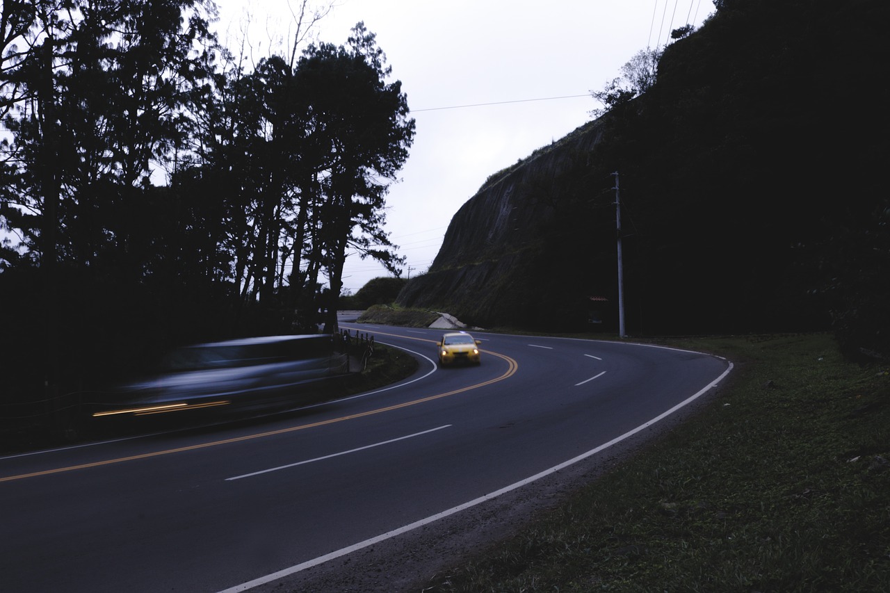 a yellow car driving down a curvy road, a picture, by Marshall Arisman, unsplash, realism, 3 am, bay area, kodak 4 0 0, dark photo