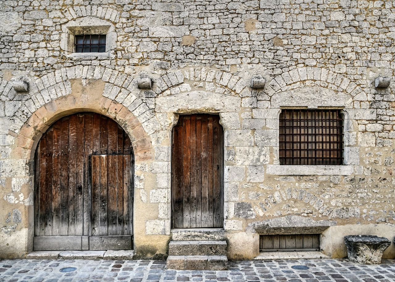 a stone building with two wooden doors and a bench, a photo, by Cedric Peyravernay, shutterstock, romanesque, high detail photo of a deserted, interesting textures, photo of a beautiful, 1792