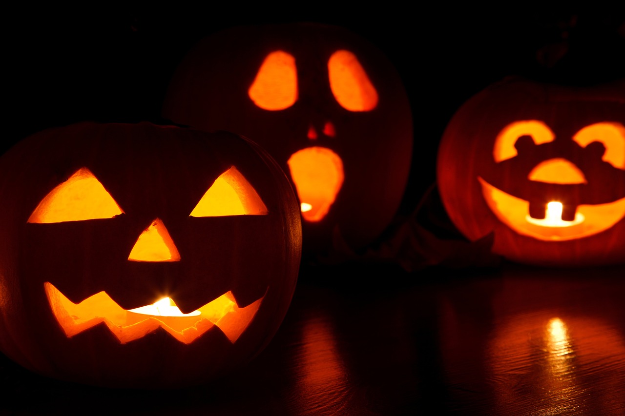 a group of carved pumpkins sitting on top of a table, a portrait, shutterstock, hard lighting!, 3 4 5 3 1, lights on, in a row