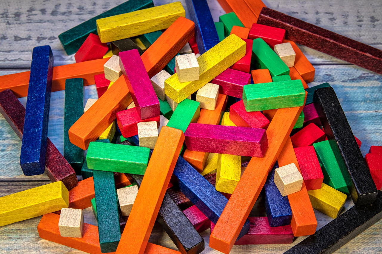 a pile of wooden blocks sitting on top of a table, a jigsaw puzzle, color field, rich vivid vibrant colors, lumnoius colorful, chalk, board games