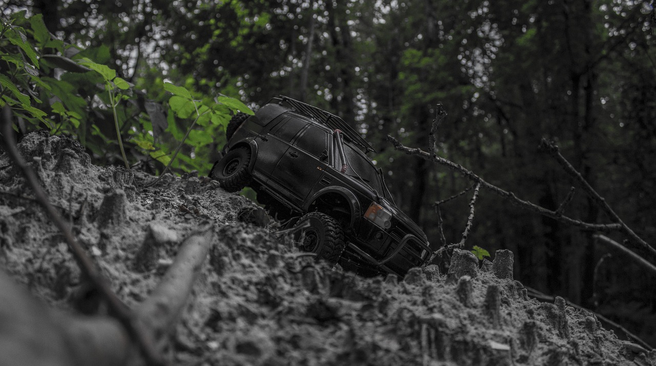 a toy jeep is stuck in the mud, a tilt shift photo, unsplash, photorealism, dnd in a dark forest, low angle!!!!, dark-toned product photos, stealthy