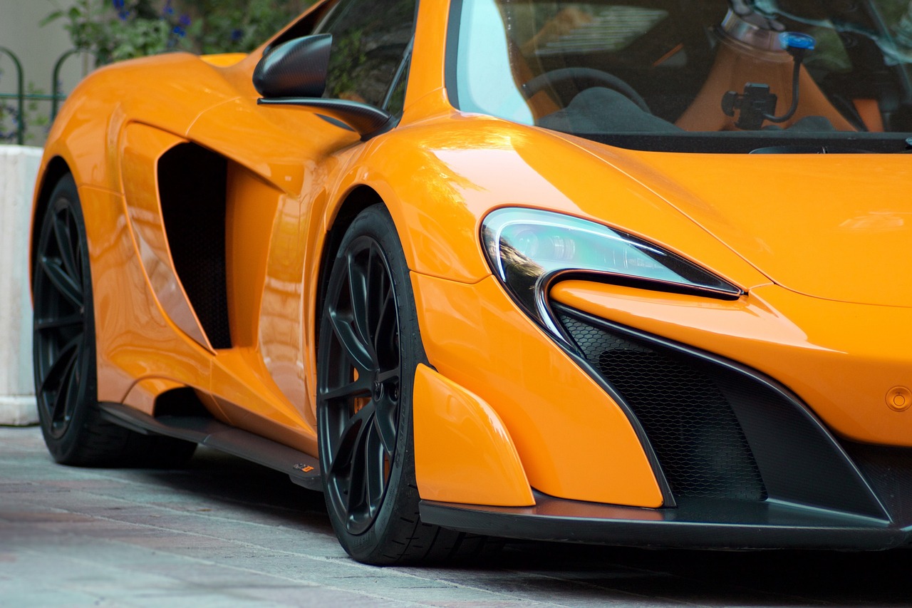 an orange sports car parked on the side of the road, by Reuben Tam, pexels, photorealism, mclaren, 4k detail post processing, ears, immense detail