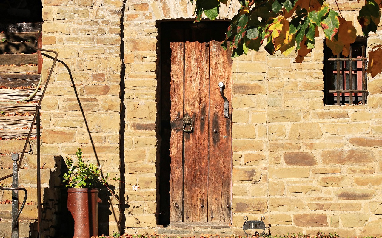 a wooden door sitting on the side of a brick building, renaissance, autumn season, canvas, farm, in the sun